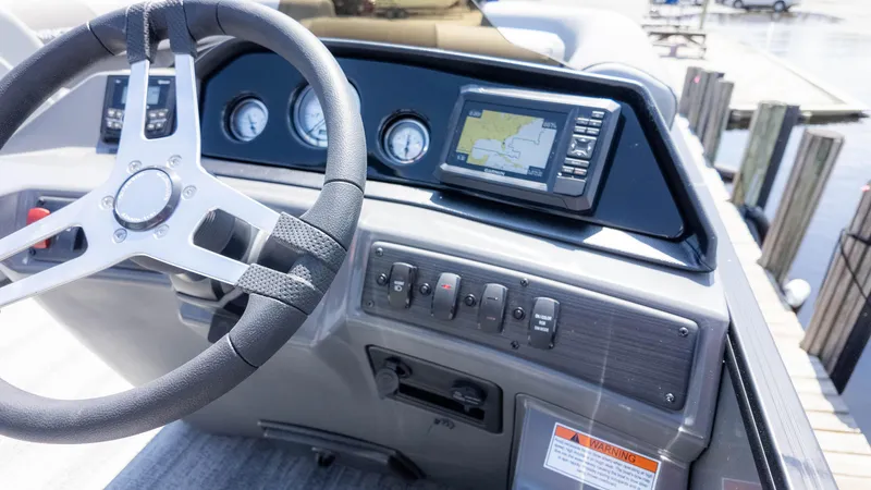 Slide: The Image of 2025 Bennington 23 SSB boat dashboard with steering wheel and navigation display. - 24