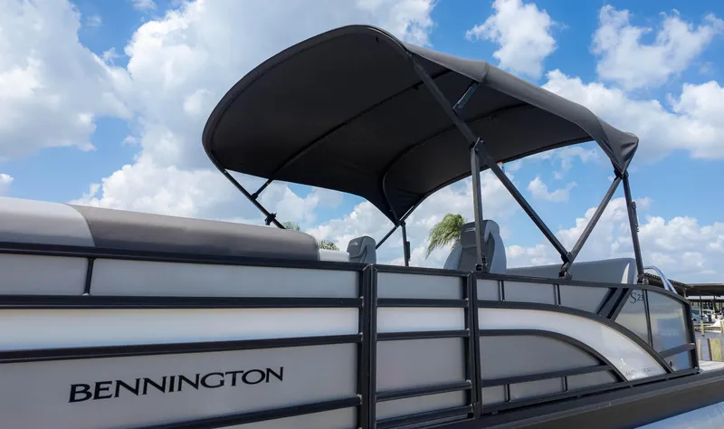 Slide: The Image of 2025 Bennington 23 SSB pontoon boat with canopy under a blue sky. - 3