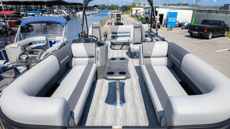 Slide: The Image of 2025 Bennington 23 SSB pontoon boat with spacious seating and modern design at a marina. - 4