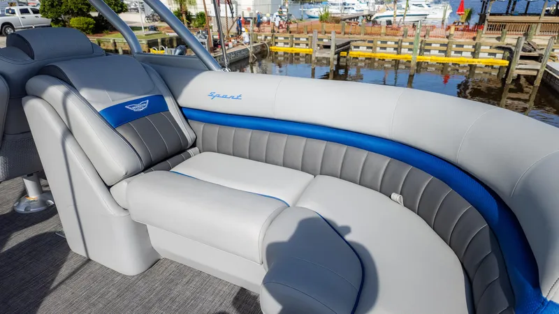 Slide: The Image of 2024 Bennington 24 LXSFBA boat interior with luxurious gray and blue seating by the dock. - 15
