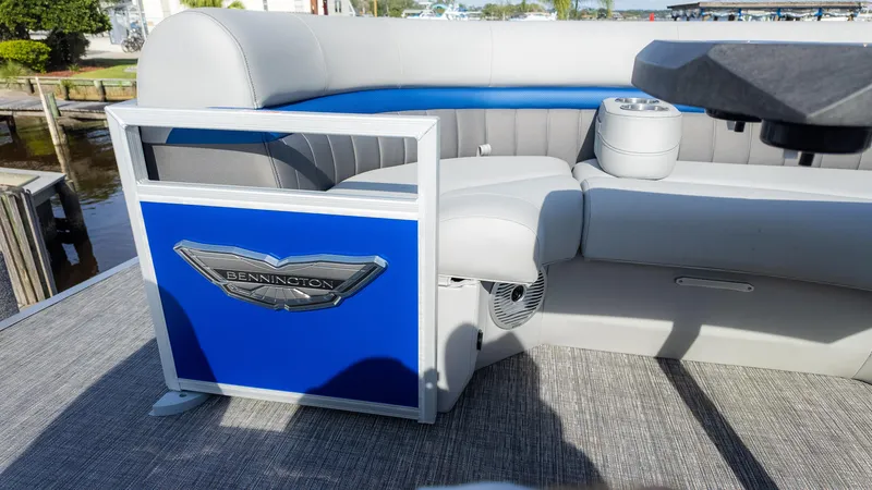 Slide: The Image of 2024 Bennington 24 LXSFBA pontoon boat interior with gray seating and blue accents. - 22