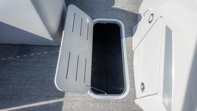 Slide: The Image of Open storage compartment on 2024 Bennington 24 LXSFBA boat, featuring sleek design and carpeted interior. - 25