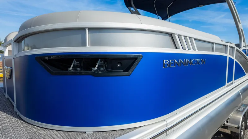 Slide: The Image of 2024 Bennington 24 LXSFBA pontoon boat with sleek blue exterior design. - 4