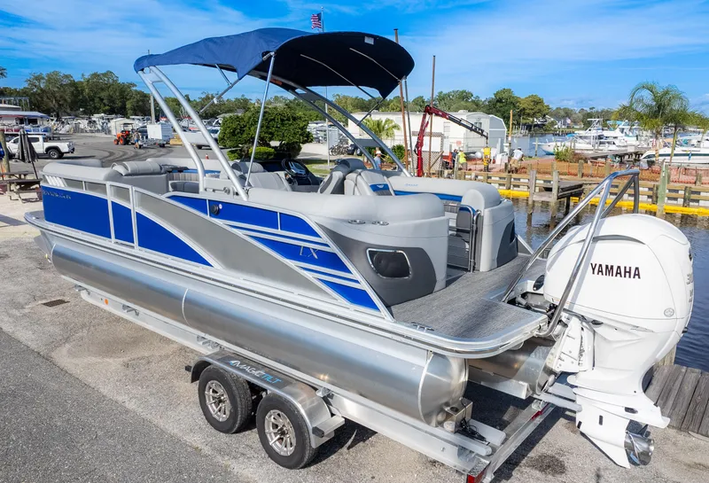 Slide: The Image of 2024 Bennington 24 LXSFBA pontoon boat with Yamaha engine, docked at marina. - 7