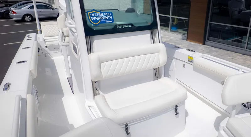 Slide: The Image of 2025 Everglades 253CC boat interior with white seating and lifetime hull warranty sticker. - 10