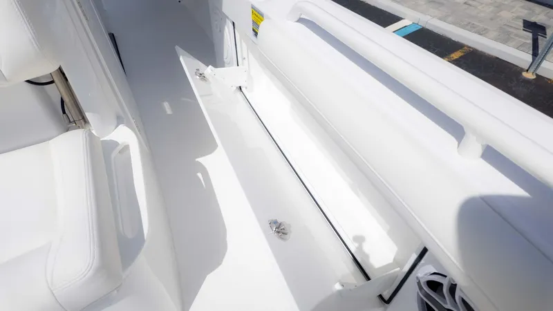 Slide: The Image of 2025 Everglades 253CC boat interior, showcasing sleek white seating and storage area. - 19