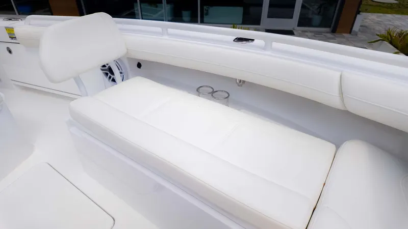 Slide: The Image of 2025 Everglades 253CC boat interior with white cushioned seating and cup holders. - 21