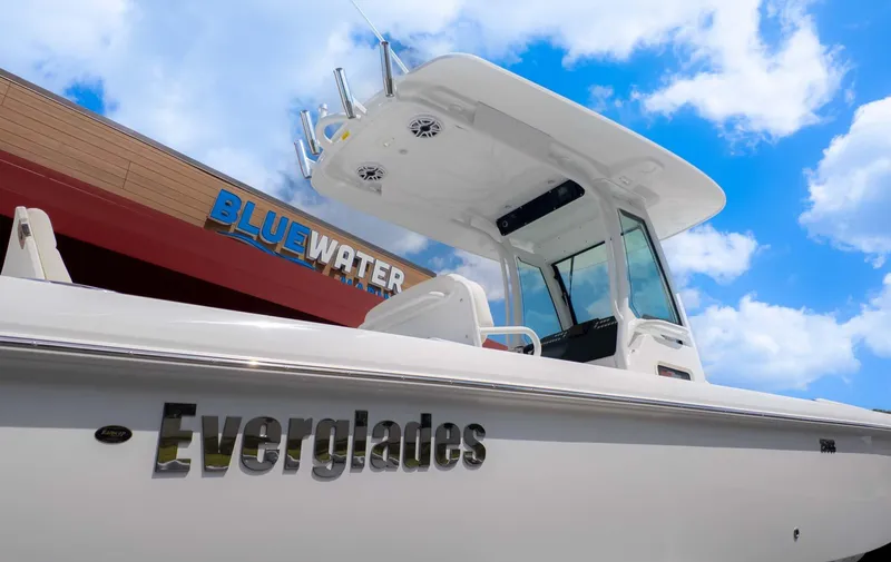Slide: The Image of 2025 Everglades 253CC boat at Bluewater Marina under a clear sky. - 3