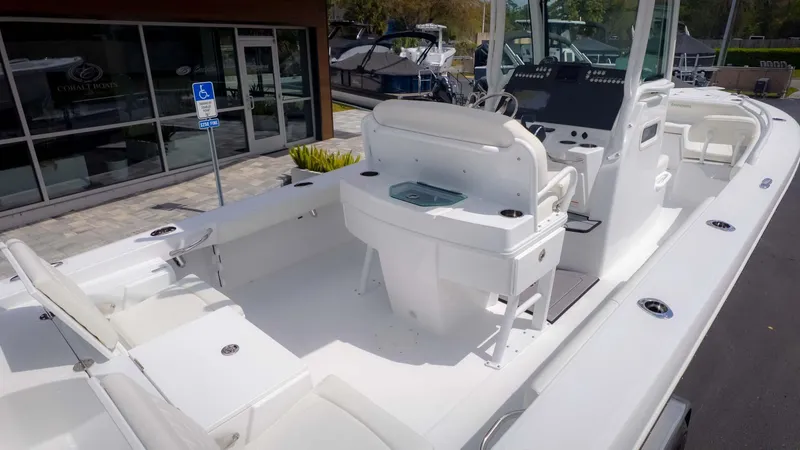 Slide: The Image of 2025 Everglades 253CC boat interior with seating and console, docked near showroom. - 7