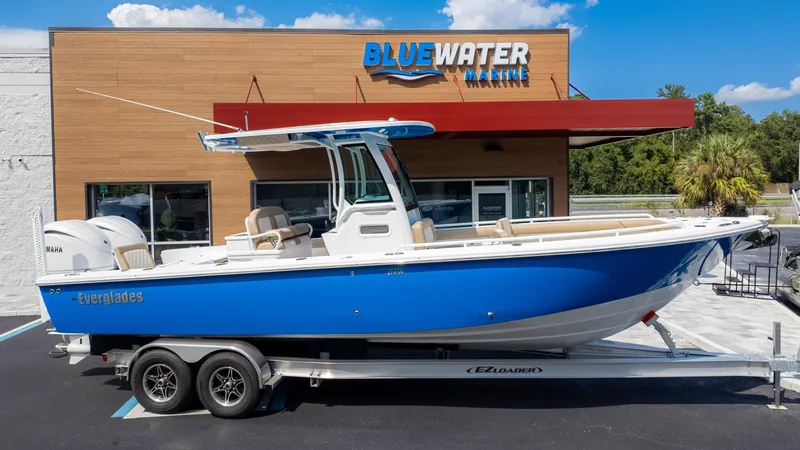 Slide: The Image of 2025 Everglades 273CC boat on trailer at Bluewater Marine dealership. - 1