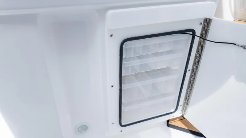 Slide: The Image of 2025 Everglades 273CC boat storage compartment with organized shelves and secure door. - 19