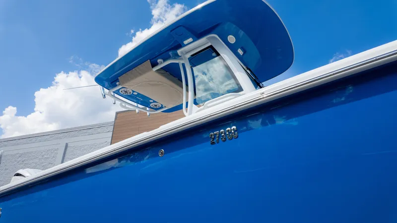 Slide: The Image of 2025 Everglades 273CC boat with blue hull under clear sky. - 2