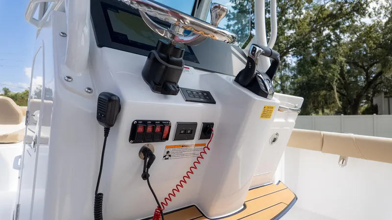 Slide: The Image of Control panel of 2025 Everglades 273CC boat with steering and switches. - 21