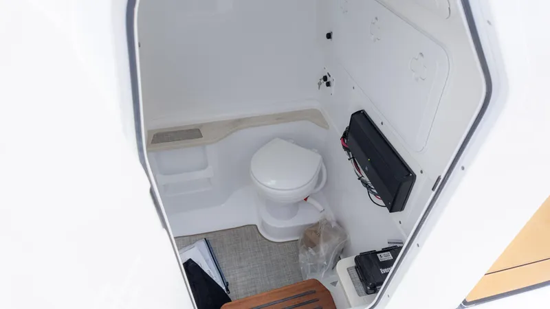 Slide: The Image of Interior of 2025 Everglades 273CC boat featuring a compact marine toilet. - 23