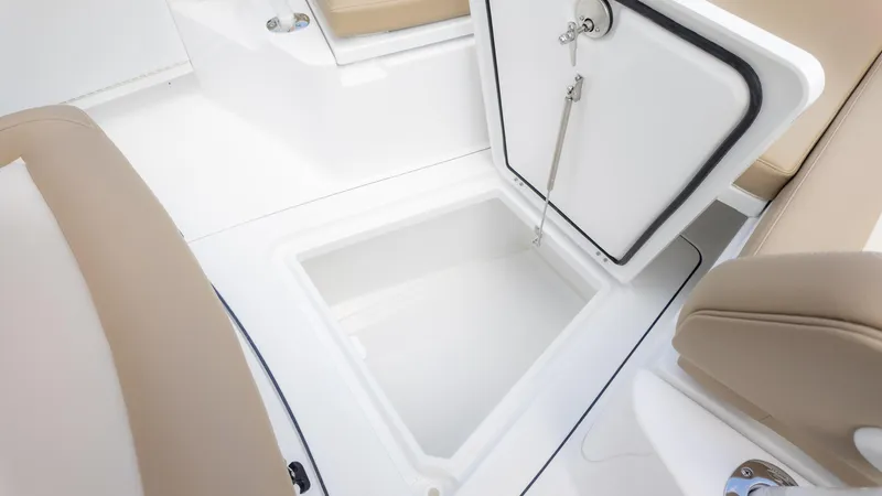 Slide: The Image of 2025 Everglades 273CC boat storage compartment with open hatch and beige seating. - 25