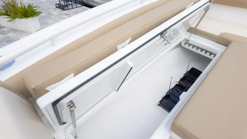 Slide: The Image of 2025 Everglades 273CC boat storage compartment with open lid and visible battery setup. - 26