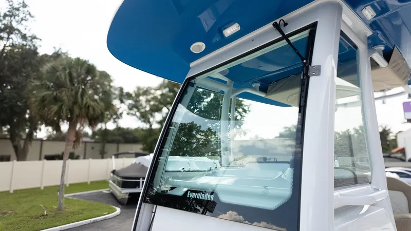 Slide: The Image of 2025 Everglades 273CC boat with blue canopy, parked outdoors. - 29