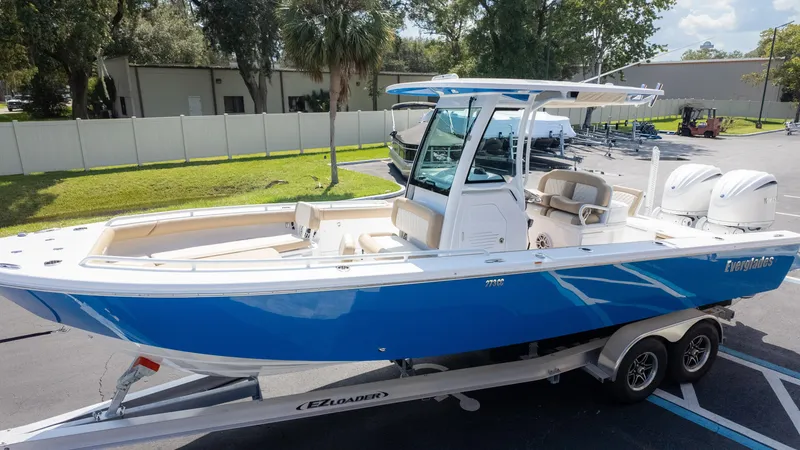 Slide: The Image of 2025 Everglades 273CC boat on trailer, blue hull, dual engines, parked outdoors. - 6