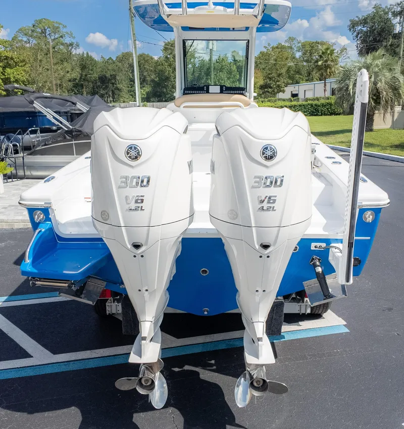 Slide: The Image of 2025 Everglades 273CC boat with dual Yamaha 300 V6 outboard engines, parked outdoors. - 8