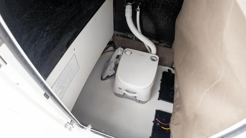 Slide: The Image of Portable toilet inside 2025 Stingray 173CC boat cabin, featuring compact design and plumbing. - 17