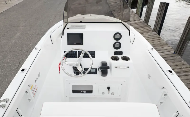 Slide: The Image of 2025 Stingray 173CC boat dashboard with steering wheel, controls, and gauges at dockside. - 8