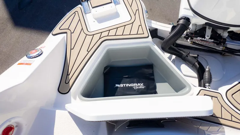 Slide: The Image of 2025 Stingray 192SC boat storage compartment with branded cover and modern design. - 13