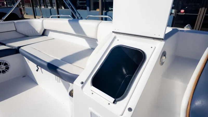 Slide: The Image of 2025 Stingray 192SC boat interior with open storage compartment and cushioned seating. - 16