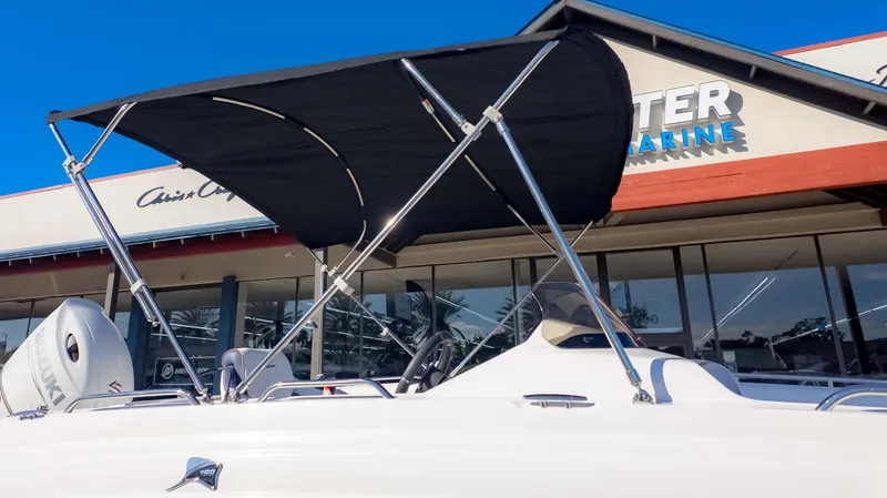 Slide: The Image of 2025 Stingray 192SC boat with canopy, displayed outside a marine dealership. - 2
