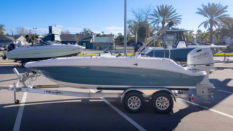 Slide: The Image of 2025 Stingray 192SC boat on trailer, parked outdoors under clear blue sky. - 5