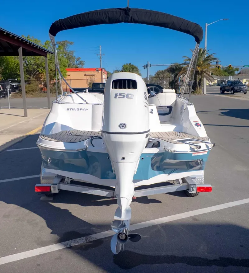 Slide: The Image of 2025 Stingray 192SC boat with 150 HP engine, parked on a sunny street. - 6