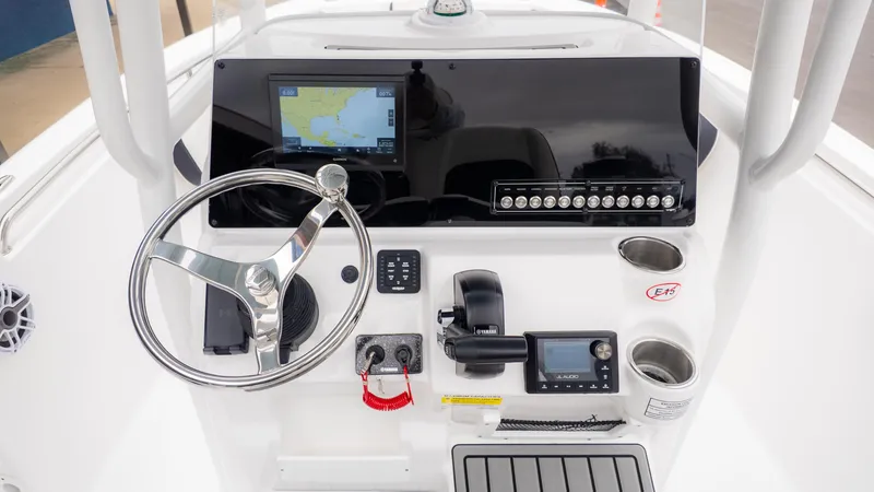 Slide: The Image of 2025 Tidewater 210CC boat console with steering wheel, navigation screen, and controls. - 13