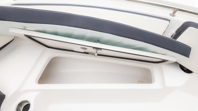 Slide: The Image of 2025 Tidewater 210CC boat storage compartment with open cushioned seat. - 16