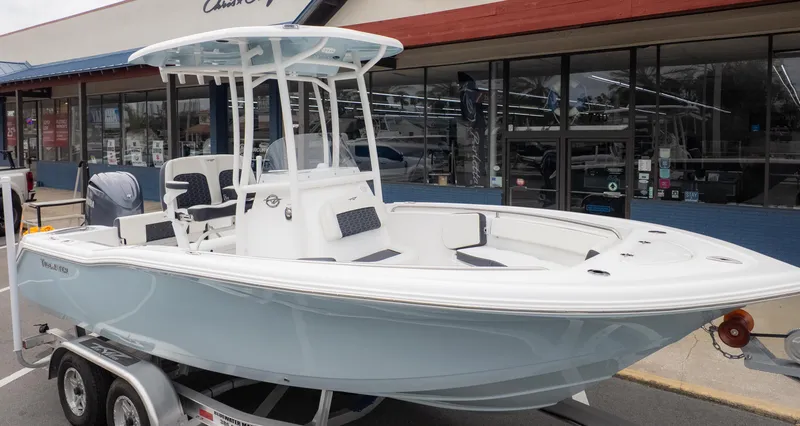 Slide: The Image of 2025 Tidewater 210CC boat on trailer outside a marine store. - 2