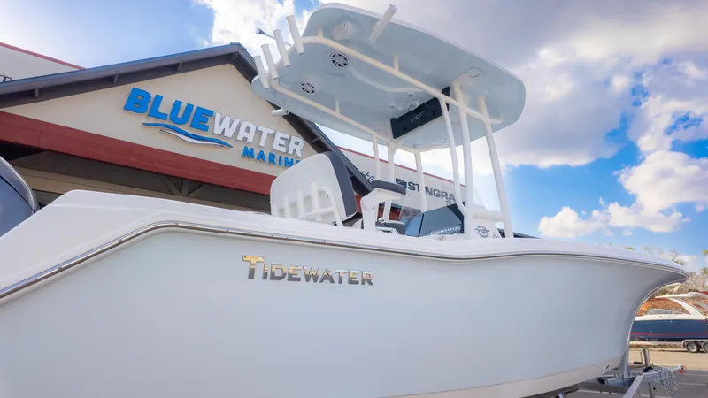 Slide: The Image of 2025 Tidewater 210CC boat at Bluewater Marine dealership under a cloudy sky. - 10