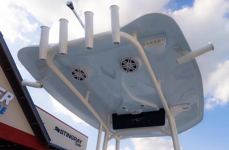 Slide: The Image of 2025 Tidewater 210CC boat T-top with rod holders and speakers against a cloudy sky. - 11