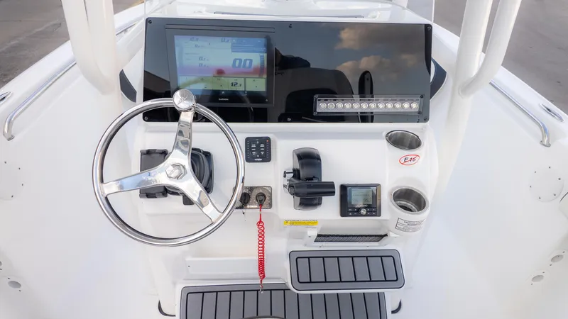 Slide: The Image of 2025 Tidewater 210CC boat dashboard with steering wheel, digital display, and controls. - 14