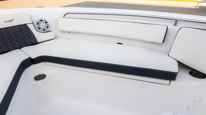 Slide: The Image of 2025 Tidewater 210CC boat interior with white cushioned seating and speaker. - 17