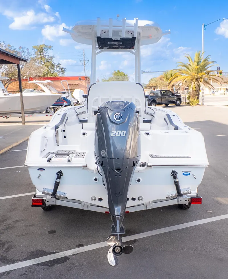 Slide: The Image of 2025 Tidewater 210CC boat with Yamaha 200 engine, parked outdoors under blue sky. - 5