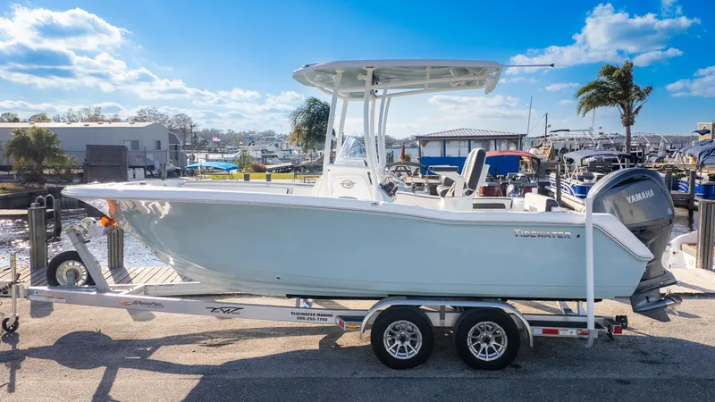 Slide: The Image of 2025 Tidewater 220cc boat on trailer, dockside, under clear blue sky. - 1