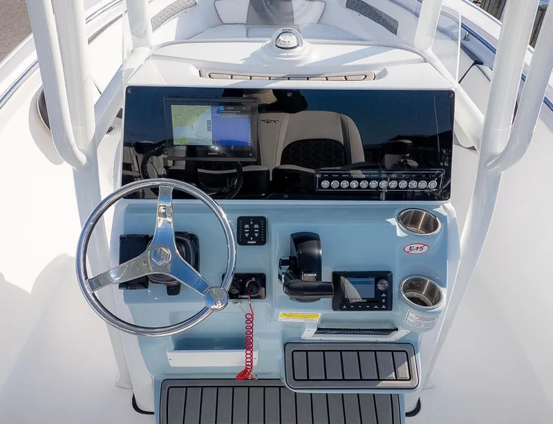 Slide: The Image of 2025 Tidewater 220cc boat console with steering wheel, navigation screen, and controls. - 13