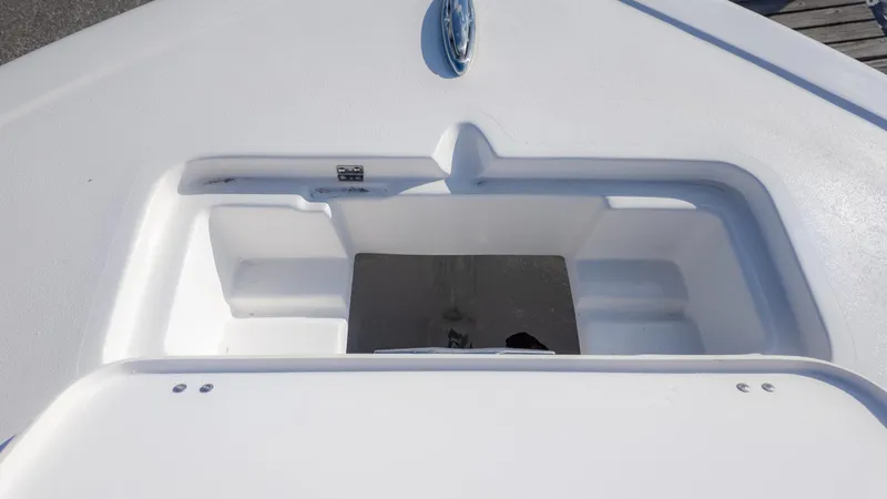 Slide: The Image of 2025 Tidewater 220cc boat storage compartment, open and empty, showcasing interior design. - 18