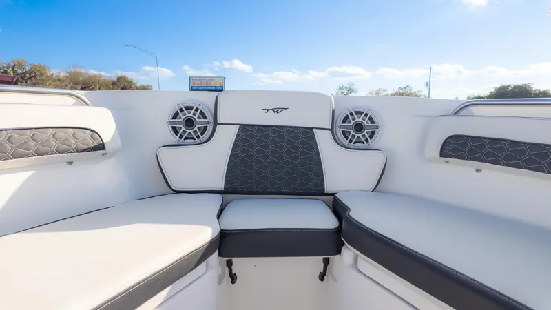 Slide: The Image of 2025 Tidewater 220cc boat interior with cushioned seating and speakers. - 19