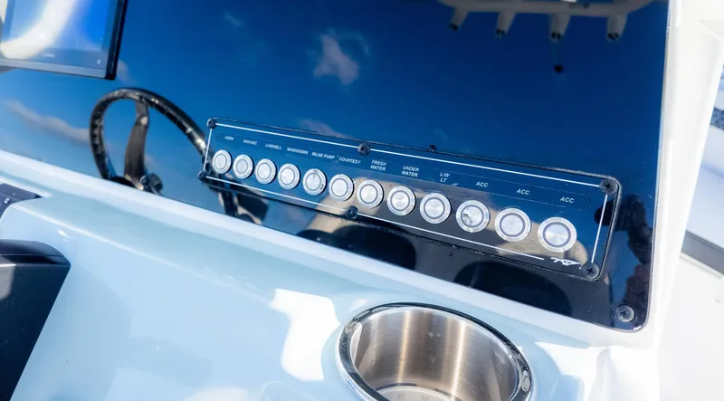 Slide: The Image of Control panel of 2025 Tidewater 220cc boat with labeled switches and cup holder. - 24