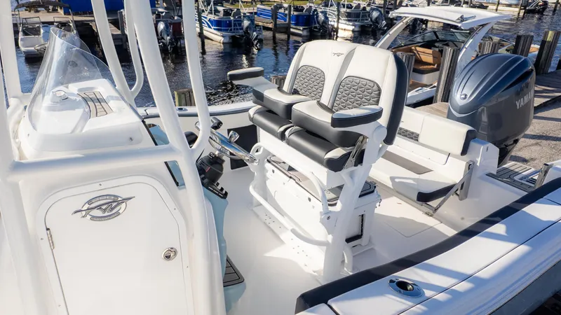 Slide: The Image of 2025 Tidewater 220cc boat interior with dual seating and Yamaha engine at marina. - 4