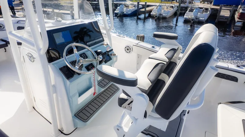 Slide: The Image of 2025 Tidewater 220cc boat interior with modern helm and seating at marina. - 5