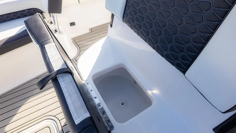 Slide: The Image of 2025 Tidewater 2500 Carolina Bay boat interior with sleek seating and storage compartment. - 26