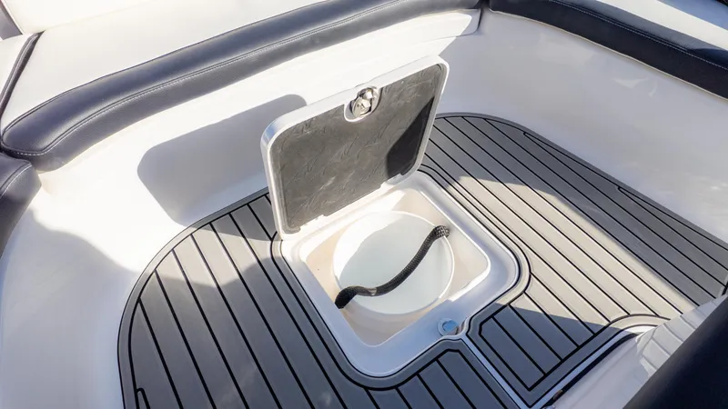 Slide: The Image of 2025 Tidewater 2500 Carolina Bay boat interior with storage compartment and cushioned seating. - 27