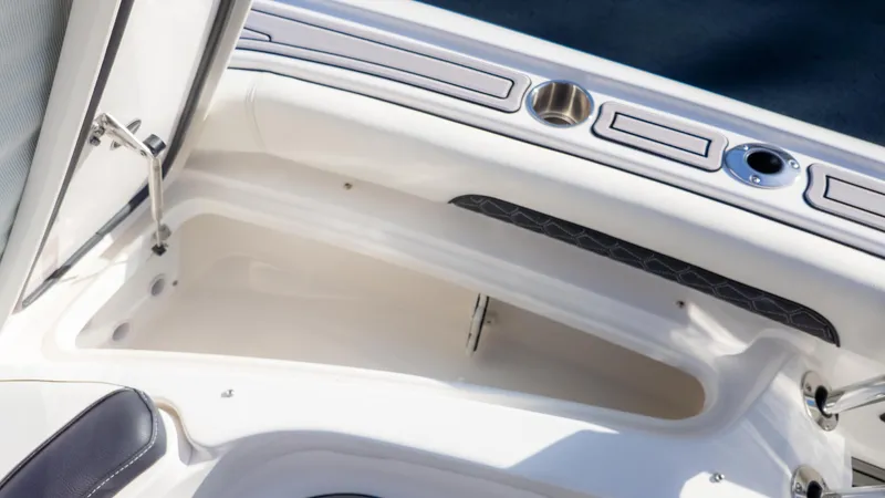 Slide: The Image of 2025 Tidewater 2500 Carolina Bay boat storage compartment with cup holders and sleek design. - 29