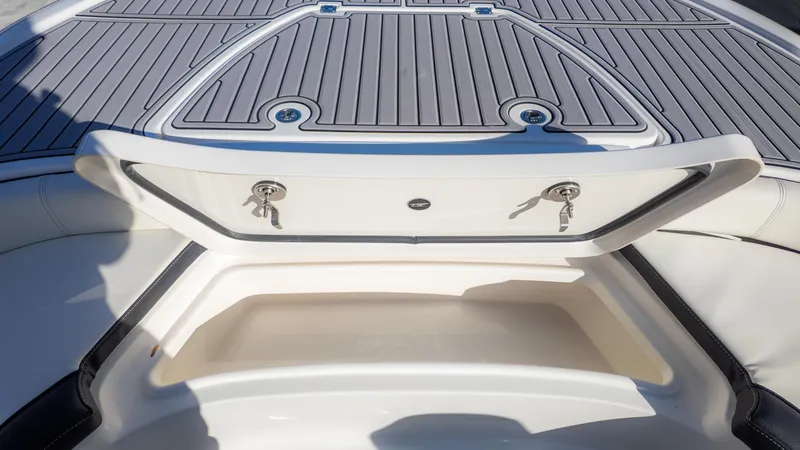 Slide: The Image of 2025 Tidewater 2500 Carolina Bay boat storage compartment with open lid and keys. - 31