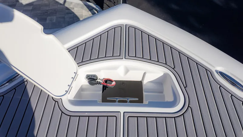 Slide: The Image of 2025 Tidewater 2500 Carolina Bay boat storage compartment with open hatch and sleek deck design. - 33
